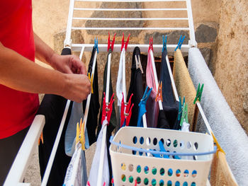 Midsection of man adjusting clothes on rack