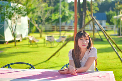 Young woman writing in book at park