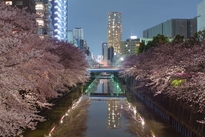 Canal against city during sunset