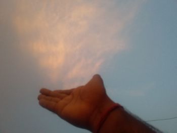 Midsection of person against sky during sunset