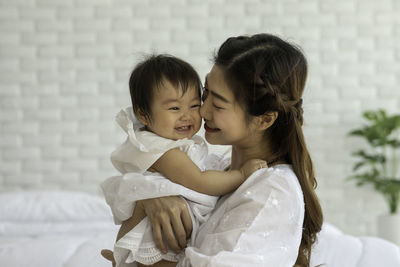 Cheerful mother with daughter at home