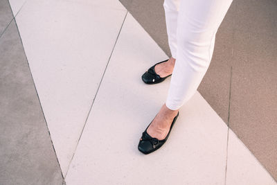 Low section of woman standing on footpath