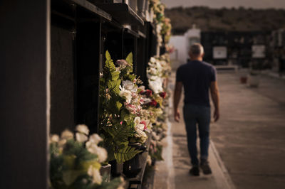 Man walking and mourning his family in cemetery