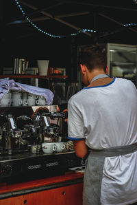 Rear view of man working at dusk