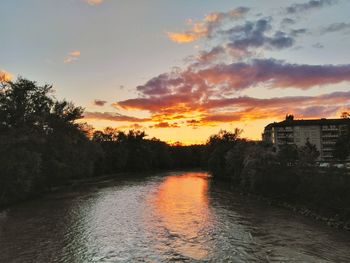 Scenic view of river against sky at sunset