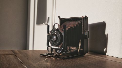 Close-up of antique camera on table with shadow on wall