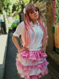 Portrait of woman with pink hair standing on street