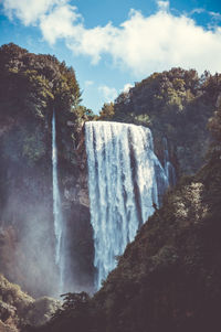 Low angle view of waterfall against sky