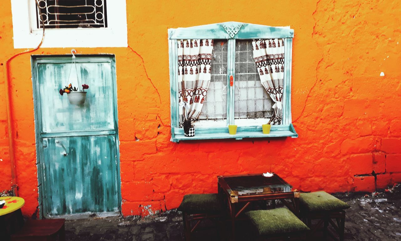 built structure, architecture, wall - building feature, building exterior, day, text, graffiti, no people, window, outdoors, building, communication, wall, residential district, orange color, art and craft, seat, creativity, door, western script