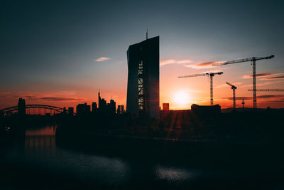 Silhouette of buildings in city during sunset