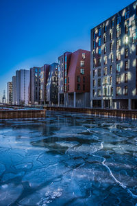 Buildings by swimming pool against blue sky