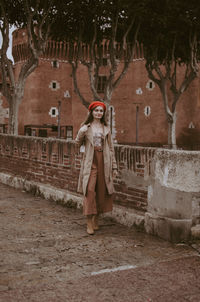 Portrait of woman standing against brick wall