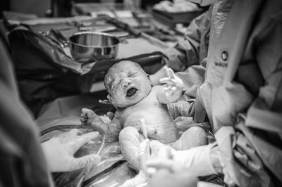 High angle view of doctors holding new born baby at hospital