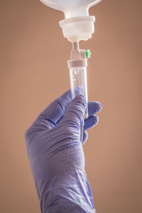 Close-up of hand holding cross against the background