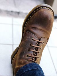 Low section of person wearing leather shoes