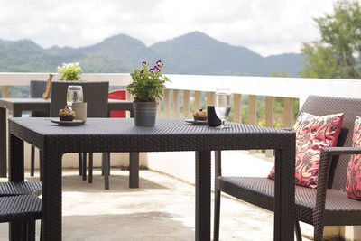 Potted plants on table by balcony against sky