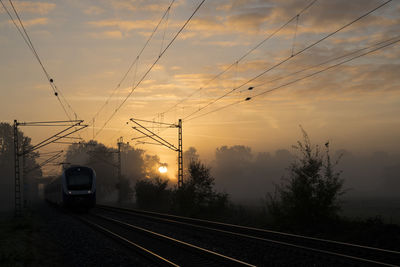 Railroad tracks against sky during sunrise