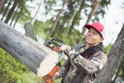 Woman using chainsaw