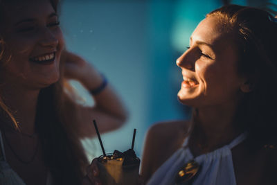 Close-up of smiling female friends having drink