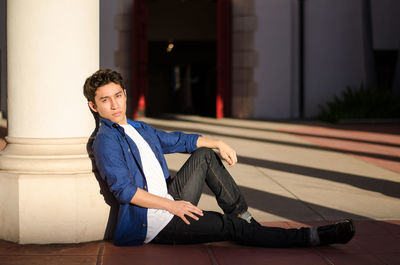 Portrait of handsome young man leaning on column