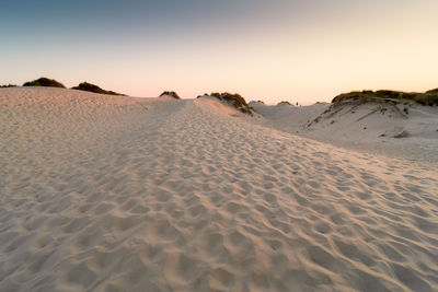 Sand dunes in desert against clear sky