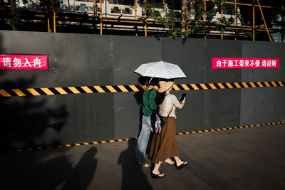 Woman with umbrella sign on zebra crossing