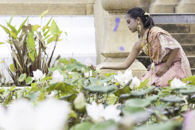 Side view of woman with pink flowers against blurred background
