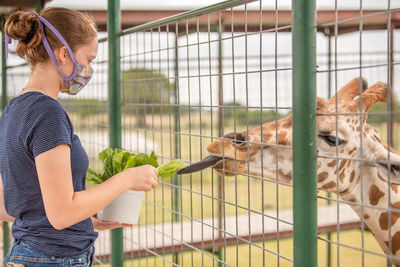 Side view of young woman looking at zoo