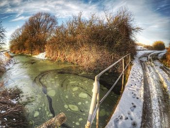 Frozen river against sky during winter