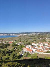 Scenic view of sea and buildings against clear blue sky