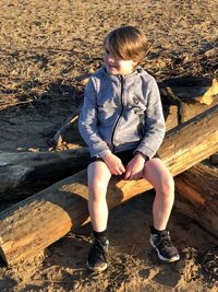 Girl sitting on wood