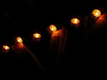 Low angle view of illuminated lanterns hanging at night