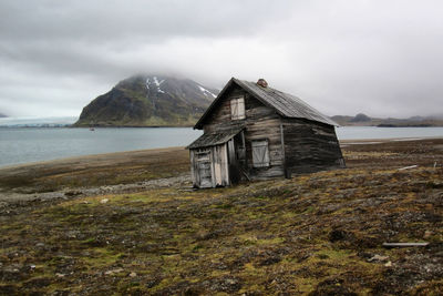 Abandoned building by sea against sky