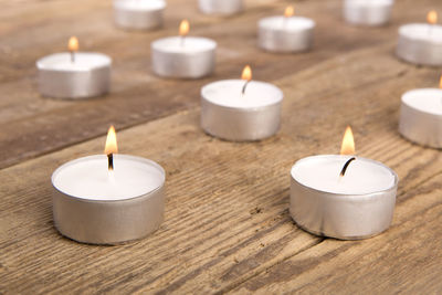 White candles in front of a wooden background