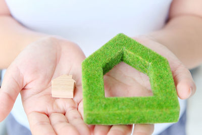 Midsection of woman holding model homes