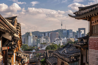 View of cityscape against cloudy sky