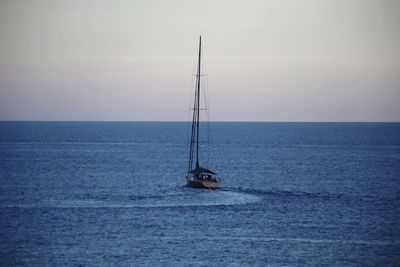 Sailboat sailing in sea against sky