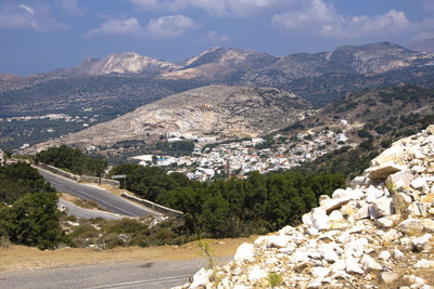 Aerial view of townscape by mountains against sky