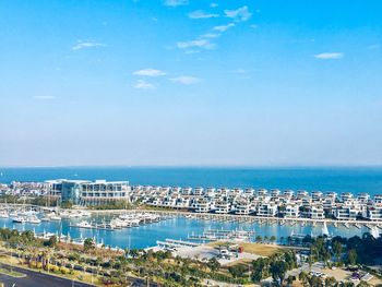 High angle view of cityscape by sea against sky