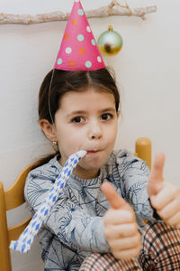 Portrait of a beautiful girl blowing a trumpet at a birthday party.