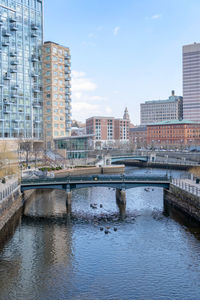 Bridge over river in city against sky