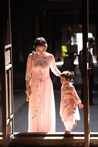 Woman with daughter standing at entrance