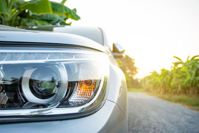 Close-up of vintage car on road against sky