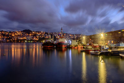 Boats moored at harbor at night