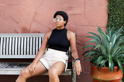 Portrait of woman sitting against wall