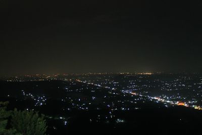 Illuminated cityscape against sky at night