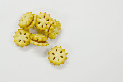 High angle view of yellow candies against white background