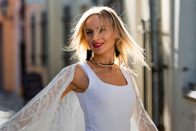 Portrait of beautiful woman standing in city