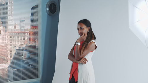 Portrait of woman standing against wall