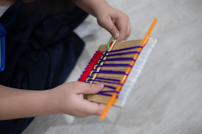 Midsection of woman holding colored pencils